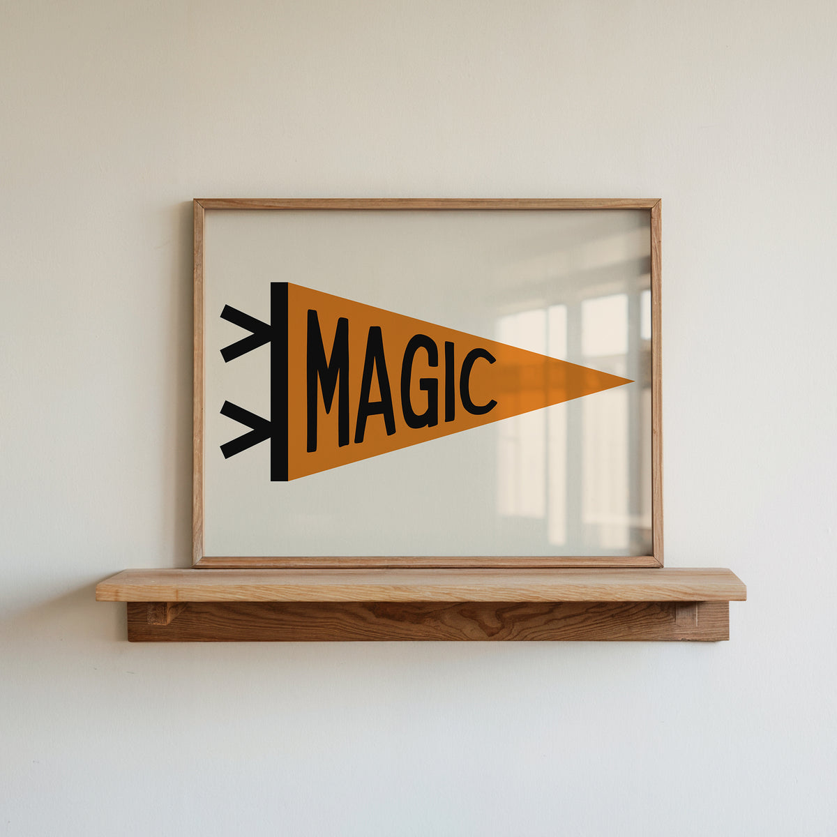Whimsical ‘MAGIC’ pennant flag print in a frame, displayed on a wooden shelf.