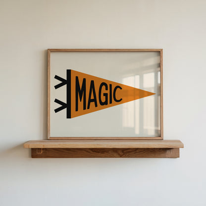 Whimsical ‘MAGIC’ pennant flag print in a frame, displayed on a wooden shelf.